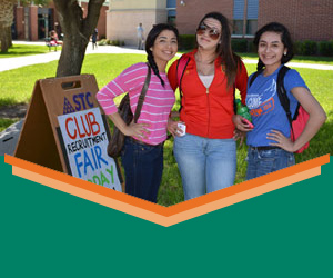 Students posing by club fair sign